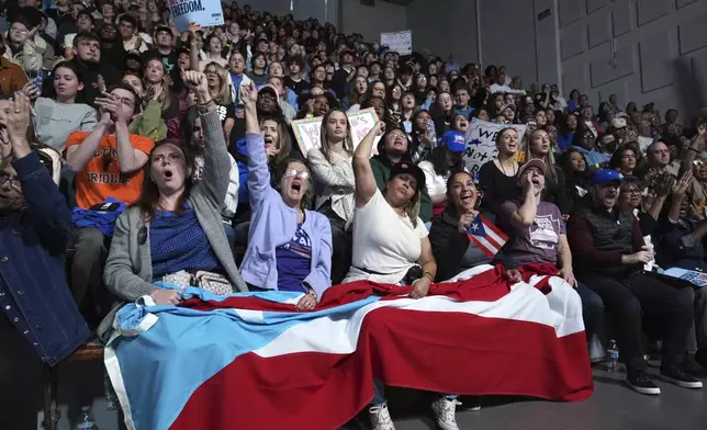 Attendees holding the flag of Puerto Rico cheer as Allentown, Pa. Mayor Matt Tuerk speaks during a campaign rally for Democratic presidential nominee Vice President Kamala Harris in Memorial Hall at Muhlenberg College in Allentown, Pa., Monday, Nov. 4, 2024. (AP Photo/Susan Walsh)