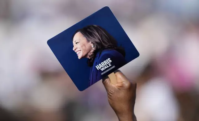 A supporter holds a sign at a campaign rally for Democratic presidential nominee Vice President Kamala Harris outside the Atlanta Civic Center, Saturday, Nov. 2, 2024. (AP Photo/Brynn Anderson)