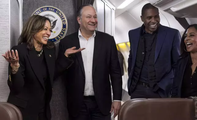 Democratic presidential nominee Vice President Kamala Harris, left, shares a laugh with second gentleman Doug Emhoff, after reuniting in Pittsburgh, Monday, Nov. 4, 2024, aboard Air Force Two along with Harris' brother-in-law Tony West and sister Maya Harris, just before taking off from Pittsburgh for her final campaign rally in Philadelphia. (AP Photo/Jacquelyn Martin, Pool)