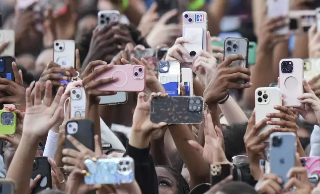 Supporters of Vice President Kamala Harris hold up their phones as she delivers a concession speech for the 2024 presidential election, Wednesday, Nov. 6, 2024, on the campus of Howard University in Washington. (AP Photo/Stephanie Scarbrough)