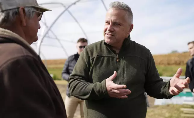 Congressman Eric Sorensen, right, talks with Denny Van Daele as he joins Rock Island County farmers and Illinois Farm Bureau leaders at a family farm in Taylor Ridge, Ill., Monday, Oct. 14, 2024. They discussed the status of the farm bill, the effects of severe weather on farms, and Sorensen's efforts on behalf of Illinois producers. (AP Photo/Nam Y. Huh)