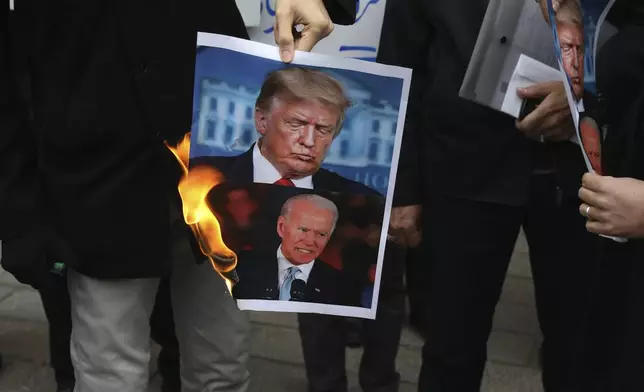 FILE — A group of protesters burn pictures of then-U.S. President Donald Trump, top, and then-President-elect Joe Biden in a gathering in front of Iranian Foreign Ministry on Saturday, Nov. 28, 2020, in Tehran, Iran. (AP Photo/Vahid Salemi, File)