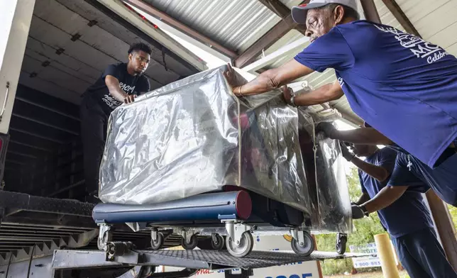 Voting machines are loaded onto trucks from a warehouse in New Orleans East to be delivered across the parish on Monday, Nov. 4, 2024, the day before the presidential election. (Chris Granger/The Times-Picayune/The New Orleans Advocate via AP)