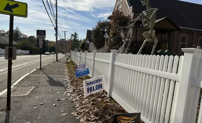 Halloween decorations and political signs for the election are displayed along the street Thursday, Oct. 31, 2024, in Portland, Maine. (AP Photo/Patrick Whittle)