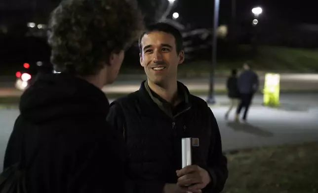 Republican congressional candidate Austin Theriault, right speaks with Carlos Kennelly, left, Tuesday, Nov. 5, 2024 outside the Cross Insurance Center in Bangor, Maine. (AP Photo/Joel Page)