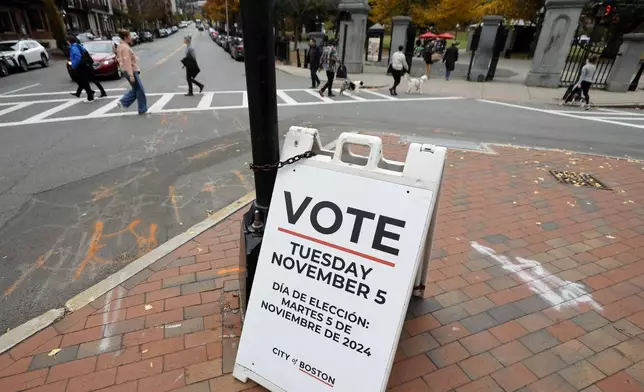 A sign urging people to vote is displayed at the intersection of Beacon and Charles Street, Saturday, Nov. 2, 2024, in Boston. (AP Photo/Michael Dwyer)