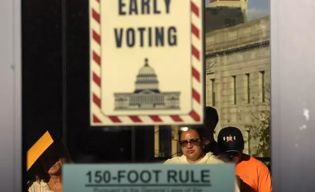 Voters stand in line as they prepare to vote during early voting in the general election, Friday, Nov. 1, 2024, in Fall River, Mass. (AP Photo/Steven Senne)