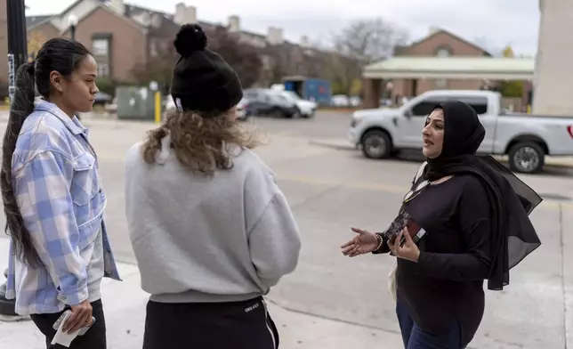 Farah Khan, right, co-chair of the Abandon Harris Michigan campaign, tries to convince pedestrians to vote for Green Party presidential candidate Jill Stein, Monday, Nov. 4, 2024, in Dearborn, Mich., the nation's largest Arab-majority city. (AP Photo/David Goldman)