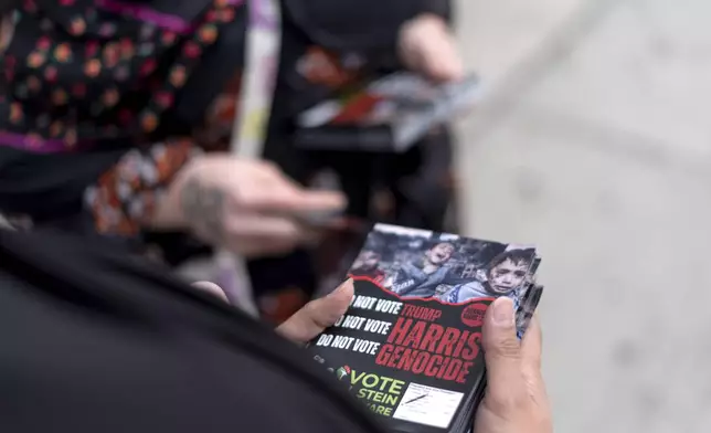 Farah Khan, right, and Chelsey Salama, with the Abandon Harris movement, prepare fliers to hand out to pedestrians encouraging them to vote for Green Party presidential candidate Jill Stein, Monday, Nov. 4, 2024, in Dearborn, Mich., the nation's largest Arab-majority city. (AP Photo/David Goldman)