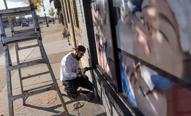 Adam Hameed, paints the exterior of a skin care center, Wednesday, Nov. 6, 2024, in Dearborn, Mich., the nation's largest Arab-majority city. (AP Photo/David Goldman)