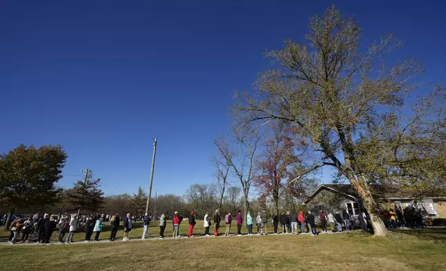 People wait in line to cast their ballots at an early voting location, Thursday, Oct. 31, 2024, in Blue Springs, Mo. (AP Photo/Charlie Riedel)