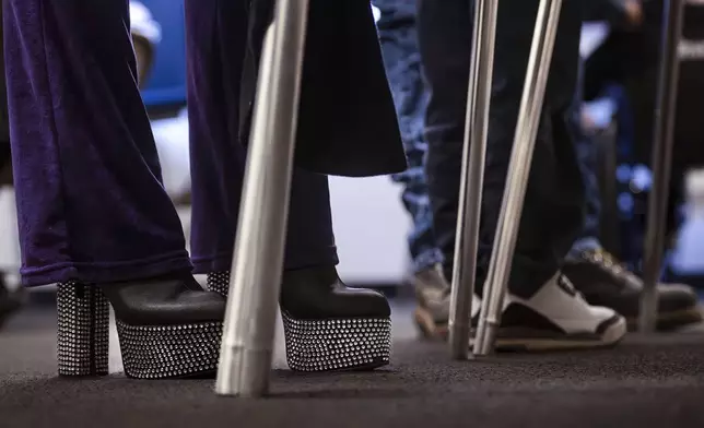 Natalie Garcia, 38, wears gemstone heels while she votes on Election Day at the Clerk's Annex in northwest Albuquerque, N.M., Tuesday, Nov. 5, 2024. (Chancey Bush/The Albuquerque Journal via AP)