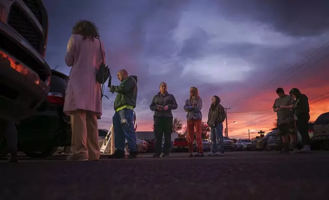 People wait in line to vote on Election Day at the Bernalillo County Visitor Center while the sunsets in the South Valley of Albuquerque, N.M., on Tuesday, Nov. 5, 2024. (Chancey Bush/The Albuquerque Journal via AP)
