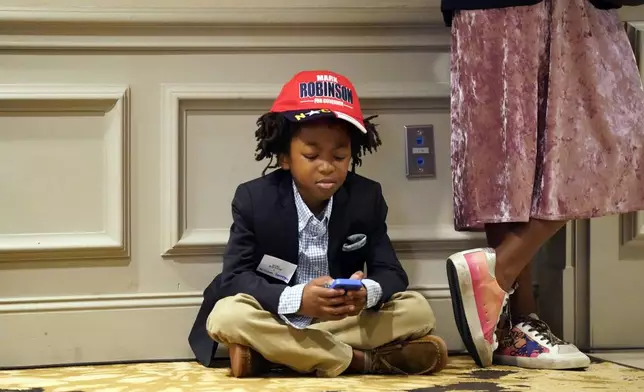 William Kornegay III, 8, of Sanford, N.C., waits during an election night watch party for Republican North Carolina gubernatorial candidate Lt. Gov. Mark Robinson, Tuesday, Nov. 5, 2024, in Raleigh, N.C. (AP Photo/Chuck Burton)