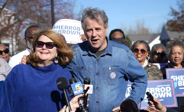 Sen. Sherrod Brown, D-Ohio, right, speaks to the media with his wife Connie Schultz, left, after voting Tuesday, Nov. 5, 2024, in Cleveland. (AP Photo/Sue Ogrocki