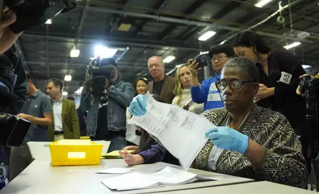 An election worker demonstrates mail-in ballot processing during a media preview at the Philadelphia Election Warehouse, in Philadelphia, Friday, Oct. 25, 2024. (AP Photo/Matt Rourke)