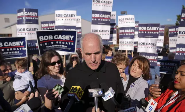 Sen. Bob Casey, D-Pa., left, stops to speak to members of the media before voting, Tuesday, Nov. 5, 2024, in Scranton, Pa. (AP Photo/Matt Rourke)