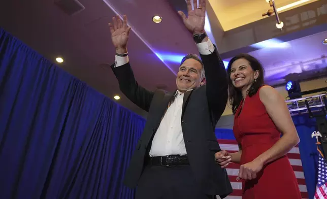 Republican Pennsylvania Senate candidate David McCormick, left, waves to the crowd while on stage with his wife, Dina Powell, during an election night watch party, Wednesday, Nov. 6, 2024, in Pittsburgh. (AP Photo/Gene J. Puskar)