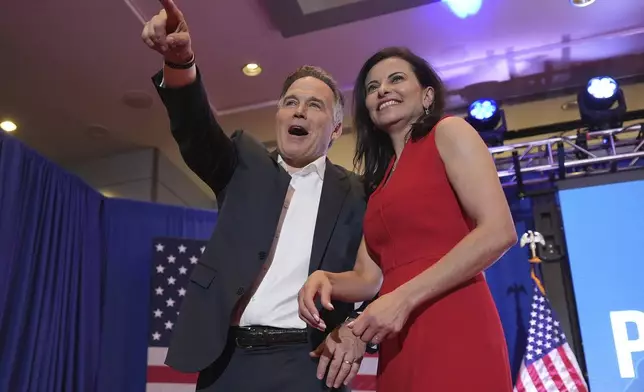 Republican Pennsylvania Senate candidate David McCormick, left, points to the crowd while on stage with his wife, Dina Powell, during an election night watch party, Wednesday, Nov. 6, 2024, in Pittsburgh. (AP Photo/Gene J. Puskar)