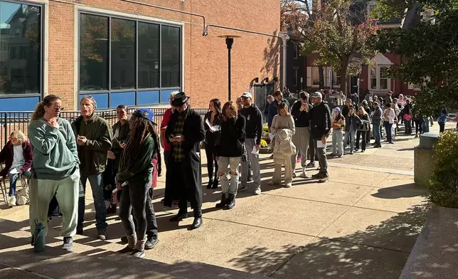 People wait in line outside the Bucks County government building to apply for an on-demand mail ballot on the last day to request one in Doylestown, Pa., Tuesday, Oct. 29, 2024. (AP Photo/Mike Catalini)