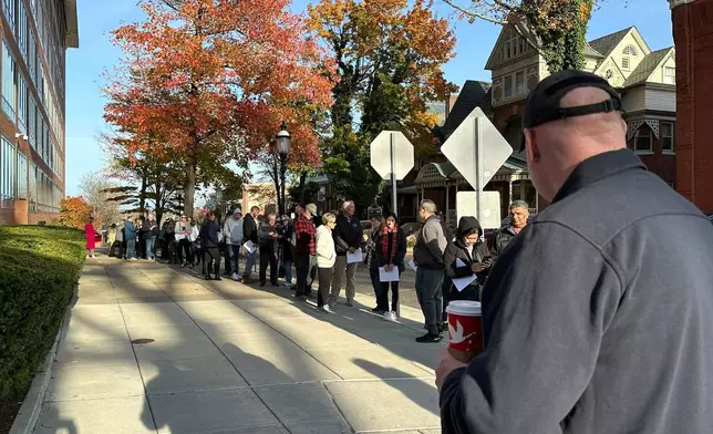 People wait in line outside the Bucks County government building to apply for an on-demand mail ballot on the last day to request one in Doylestown, Pa., Tuesday, Oct. 29, 2024. (AP Photo/Mike Catalini)