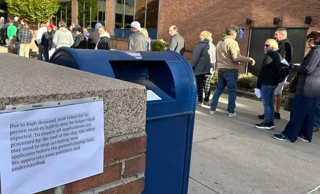 People wait in line outside the Bucks County government building to apply for an on-demand mail ballot on the last day to request one in Doylestown, Pa., Tuesday, Oct. 29, 2024. (AP Photo/Mike Catalini)