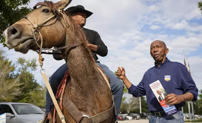 Rob Slater, left, talks to former Mayor Sylvester Turner as Turner campaigns for a seat in the U.S. House of Representatives at Lone Star College-Houston North Victory on Election Day, Tuesday, Nov. 5, 2024, in Houston. (Brett Coomer/Houston Chronicle via AP)