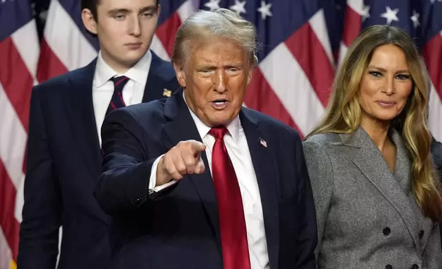 Republican presidential nominee former President Donald Trump departs as son Barron Trump, left, and former first lady Melania Trump look on at an election night watch party, Wednesday, Nov. 6, 2024, in West Palm Beach, Fla. (AP Photo/Alex Brandon)