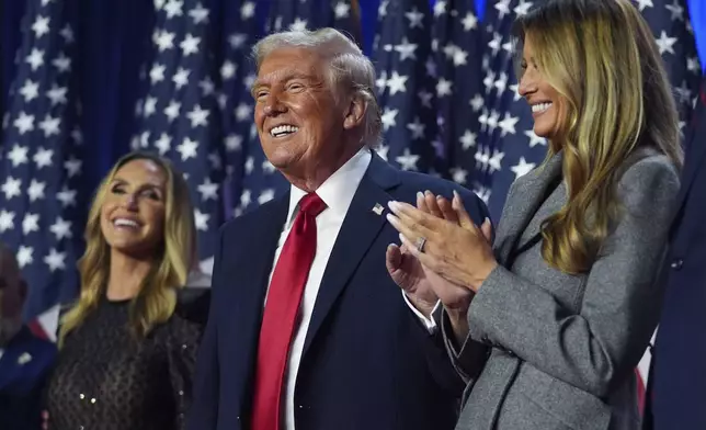 Republican presidential nominee former President Donald Trump stands on stage with former first lady Melania Trump, as Lara Trump watches, at an election night watch party at the Palm Beach Convention Center, Wednesday, Nov. 6, 2024, in West Palm Beach, Fla. (AP Photo/Evan Vucci)