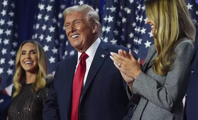 Republican presidential nominee former President Donald Trump stands on stage with former first lady Melania Trump, as Lara Trump watches, at an election night watch party at the Palm Beach Convention Center, Wednesday, Nov. 6, 2024, in West Palm Beach, Fla. (AP Photo/Evan Vucci)