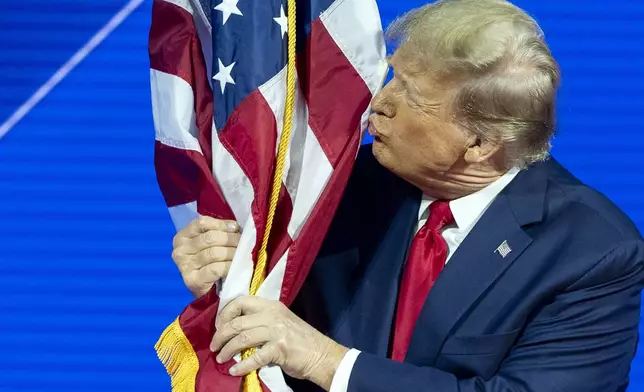 Republican presidential candidate former President Donald Trump kisses the flag as arrives to speak during the Conservative Political Action Conference, CPAC 2024, at National Harbor, in Oxon Hill, Md., Saturday, Feb. 24, 2024. (AP Photo/Alex Brandon)