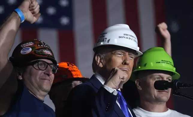 Republican presidential nominee former President Donald Trump stands on stage with steelworkers as he speaks during a campaign rally at Arnold Palmer Regional Airport, Saturday, Oct. 19, 2024, in Latrobe, Pa. (AP Photo/Evan Vucci)