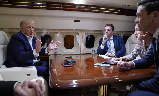 Former President Donald Trump speaks with reporters while in flight on his plane after a campaign rally at Waco Regional Airport, in Waco, Texas, Saturday, March 25, 2023, while en route to West Palm Beach, Fla. (AP Photo/Evan Vucci)