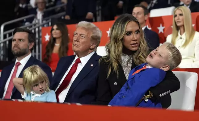 Republican presidential candidate former President Donald Trump sits with Lara Trump and her children Luke and Carolina during the 2024 Republican National Convention at the Fiserv Forum, Thursday, July 18, 2024, in Milwaukee. (AP Photo/Carolyn Kaster)