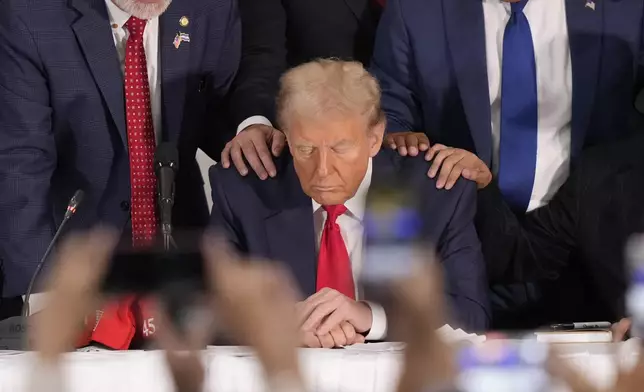 Latino leaders pray with Republican presidential nominee former President Donald Trump as he participates in a roundtable with Latino leaders Tuesday, Oct. 22, 2024, in Doral, Fla. (AP Photo/Lynne Sladky)