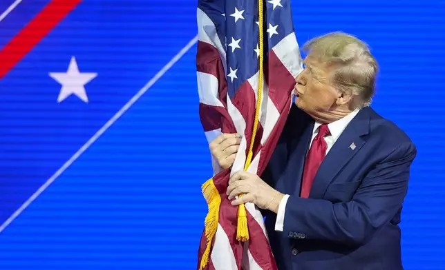 Republican presidential candidate former President Donald Trump hugs and kisses the American flag as he speaks at the Conservative Political Action Conference, CPAC 2024, at National Harbor, in Oxon Hill, Md., Saturday, Feb. 24, 2024. (AP Photo/Alex Brandon)