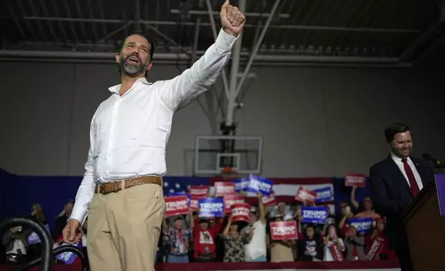 Donald Trump Jr. motions on stage with Republican vice presidential nominee Sen. JD Vance, R-Ohio, at a campaign rally Saturday, Nov. 2, 2024, in Las Vegas. (AP Photo/John Locher)