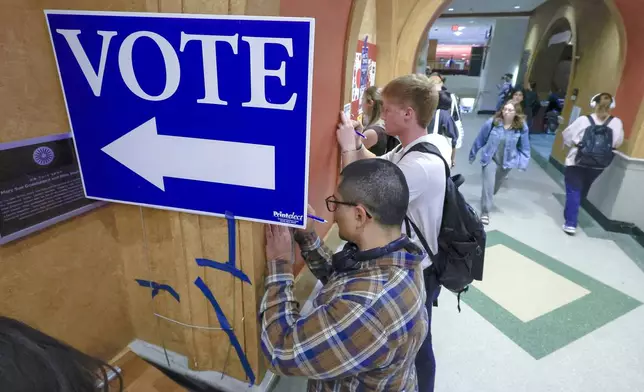 Students at The University of Wisconsin-Madison fill out ballots during the first day of Wisconsin's in-person absentee voting on the campus in Madison, Wisc., Tuesday, Oct. 22, 2024. (AP Photo/John Hart, Wisconsin State Journal)