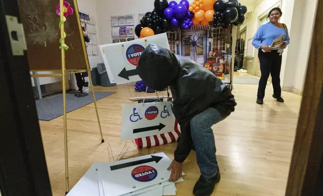 Election workers take down election signs as they close off the voting and drop off site at the Echo Park Recreation Center on Tuesday, Nov. 5, 2024, in Los Angeles. (AP Photo/Damian Dovarganes)