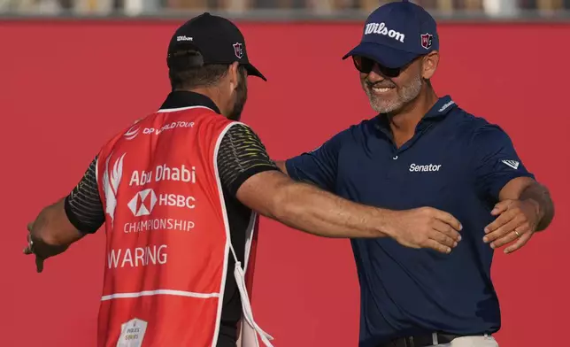 Paul Waring of England celebrates with his caddie after winning the Abu Dhabi Golf Championship in Abu Dhabi, United Arab Emirates, Sunday, Nov. 10, 2024. (AP Photo/Altaf Qadri)