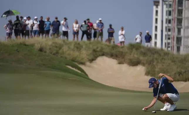 Paul Waring of England lines up a putt on the 1st green in the final round of Abu Dhabi Golf Championship in Abu Dhabi, United Arab Emirates, Sunday, Nov. 10, 2024. (AP Photo/Altaf Qadri)