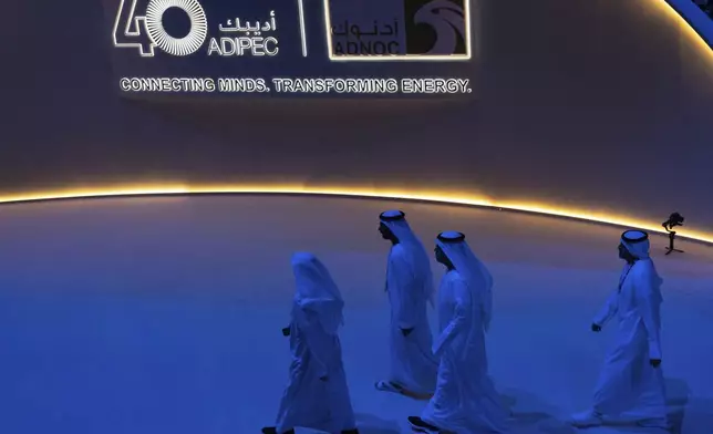 Delegates leave the hall after the inaugural session of annual Abu Dhabi International Petroleum Exhibition and Conference (ADIPEC) in Abu Dhabi, United Arab Emirates, Monday, Nov. 4, 2024. (AP Photo/Altaf Qadri)