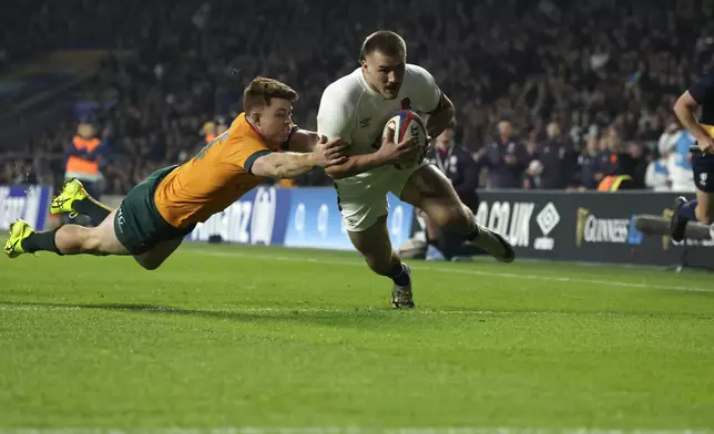 England's Ollie Sleightholme, right, scores a try as Australia's Andrew Kellaway tries to defend during the Autumn Nations series rugby union match between England and Australia, at Twickenham stadium, London Saturday, Nov. 9, 2024. (AP Photo/Ian Walton)