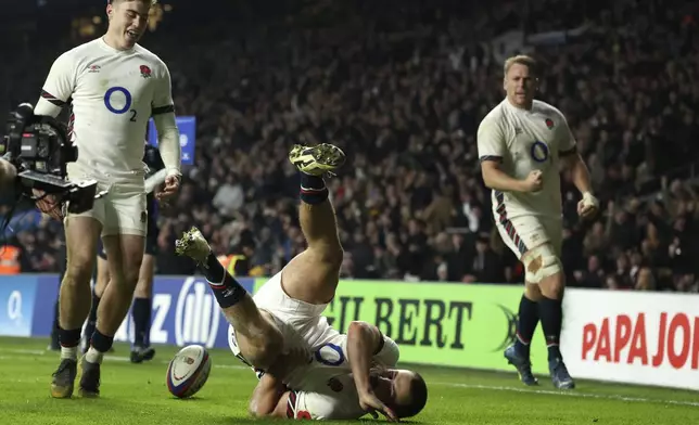 England's Ollie Sleightholme, centre, tumbles after scoring a try during the Autumn Nations series rugby union match between England and Australia, at Twickenham stadium, London Saturday, Nov. 9, 2024. (AP Photo/Ian Walton)