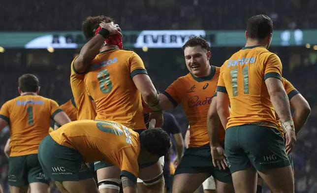 Australia's Harry Wilson, centre, is congratulated by teammates after scoring a try during the Autumn Nations series rugby union match between England and Australia, at Twickenham stadium, London Saturday, Nov. 9, 2024. (AP Photo/Ian Walton)