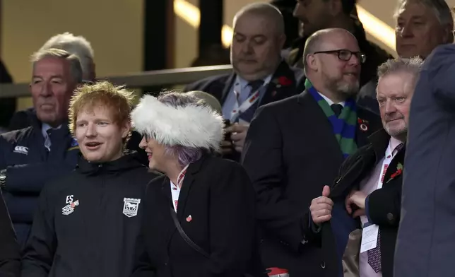 English singer-songwriter Ed Sheeran, left, attends the Autumn Nations series rugby union match between England and Australia, at Twickenham stadium, London Saturday, Nov. 9, 2024. (AP Photo/Ian Walton)