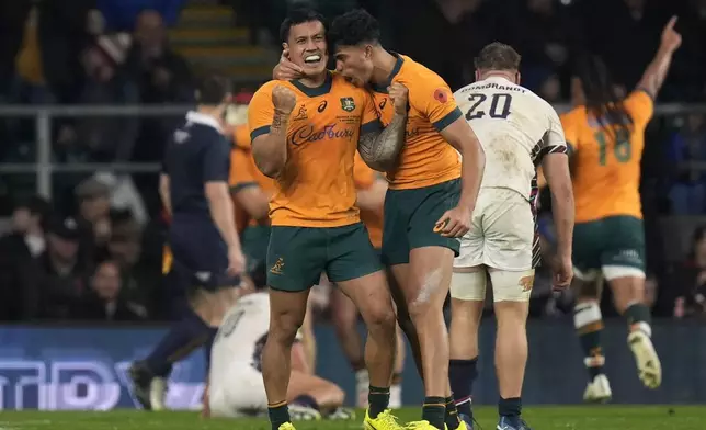 Australia's Len Ikitau, left, celebrates after team-mate Max Jorgensen, not in photo, scored a try during the Autumn Nations series rugby union match between England and Australia, at Twickenham stadium, London Saturday, Nov. 9, 2024. (David Davies/PA via AP)