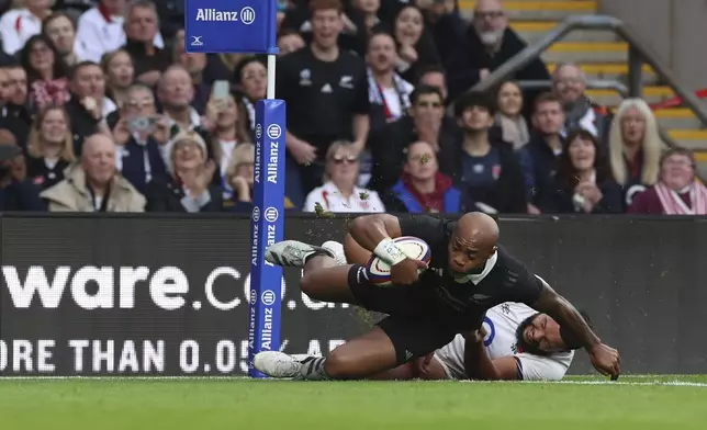 New Zealand's Mark Tele'a, front, scores a try as England's Ellis Genge tries to tackle him during the Autumn Nations Series rugby match between England and New Zealand, at Twickenham stadium, London Saturday, Nov. 2, 2024. (AP Photo/Ian Walton)