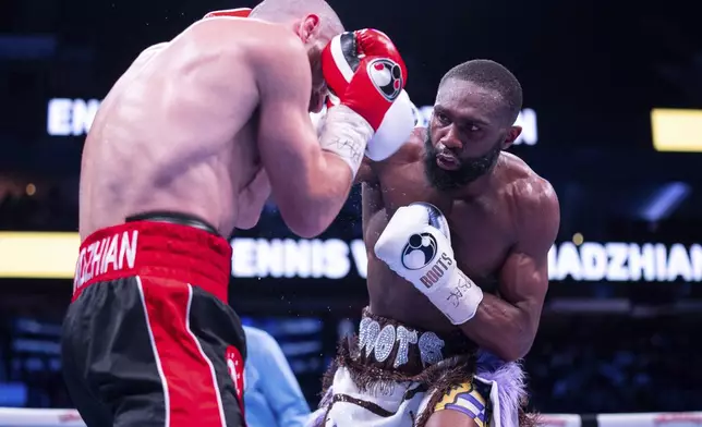 Jaron Ennis, right, throws a punch at Karen Chukhadzhian, left, during the ninth round IBF World Welterweight title bout Saturday, Nov. 9, 2024, in Philadelphia. Jaron Ennis retains his IBF World Welterweight title with a unanimous decision. (AP Photo/Chris Szagola)