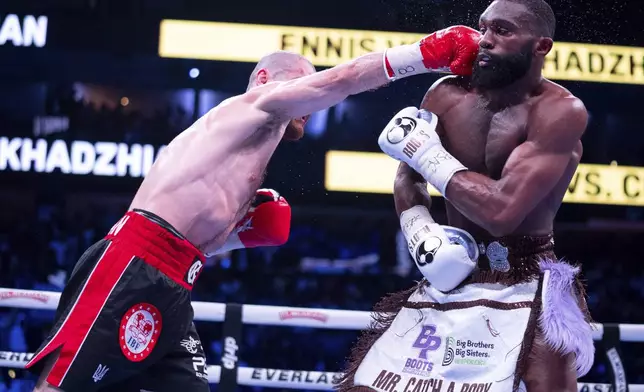 Jaron Ennis, right, takes a punch from Karen Chukhadzhian, left, during the sixth round of a IBF World Welterweight title bout Saturday, Nov. 9, 2024, in Philadelphia. Jaron Ennis retains his IBF World Welterweight title with a unanimous decision. (AP Photo/Chris Szagola)